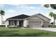 Two-story home with gray siding, two-car garage, and landscaping at 8960 Se 44Th Ct, Ocala, FL 34480