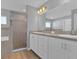 Bathroom featuring dual sinks, updated vanity, and tiled shower offers a spa-like retreat at 1065 Silas St, Haines City, FL 33844