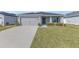 Well-maintained single-story home featuring a manicured lawn and a two-car garage at 1065 Silas St, Haines City, FL 33844