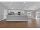 Bright, open-concept kitchen featuring a large island, stainless steel appliances, and wood-look flooring at 1065 Silas St, Haines City, FL 33844