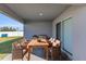 Covered outdoor patio with dining table, chairs, grill, and view of the backyard at 1065 Silas St, Haines City, FL 33844