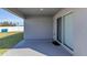 Covered patio featuring concrete flooring, a glass sliding door to the house, and backyard access at 1065 Silas St, Haines City, FL 33844