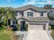 Two-story house with gray siding, a two-car garage, and a landscaped yard at 1074 Berkeley Dr, Kissimmee, FL 34744