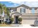 Two-story house with gray siding, gray shutters, and a two-car garage at 1074 Berkeley Dr, Kissimmee, FL 34744
