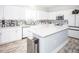 Modern white kitchen with an island and stainless steel appliances at 1074 Berkeley Dr, Kissimmee, FL 34744