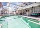 Enclosed pool and spa with covered patio and seating at 1074 Berkeley Dr, Kissimmee, FL 34744