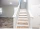 Modern staircase with white railings and wood-look treads at 1074 Berkeley Dr, Kissimmee, FL 34744