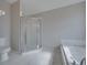 Bathroom with shower and tub, featuring neutral color palette at 140 Bentley Oaks Blvd, Davenport, FL 33896