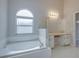Bathroom with soaking tub, double vanity, and arched window at 140 Bentley Oaks Blvd, Davenport, FL 33896