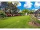 Expansive grassy backyard with mature trees and colorful landscaping at 1419 Hollingsworth Oaks Dr, Lakeland, FL 33803