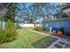Landscaped backyard with spacious grassy area, mature trees, and a brick patio at 1632 Tangerine St, Lakeland, FL 33803