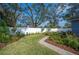 Landscaped backyard with a grassy area, flowers, and a brick pathway at 1632 Tangerine St, Lakeland, FL 33803