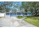 Ranch home with light blue exterior, landscaping, and a long driveway at 1632 Tangerine St, Lakeland, FL 33803