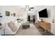 Bright living room with L-shaped sofa, wood floors, and large TV at 1632 Tangerine St, Lakeland, FL 33803