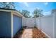 Side yard with a pathway, white fence, and access gate at 1632 Tangerine St, Lakeland, FL 33803