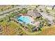 An aerial perspective showcases a pristine community pool surrounded by lush greenery and palm trees at 1878 Pristine Loop, Lakeland, FL 33811