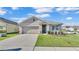 Attractive single-story home with a neat front lawn, showcasing landscaping and an attached two-car garage at 1878 Pristine Loop, Lakeland, FL 33811