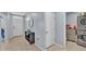 Hallway with neutral tile flooring leads to front door and laundry room with washer and dryer at 1878 Pristine Loop, Lakeland, FL 33811