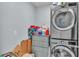 Laundry room features gray dresser and stacked washer and dryer at 1878 Pristine Loop, Lakeland, FL 33811