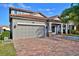 Two-story house with tile roof, paver driveway, and landscaping at 1958 Altavista Cir, Lakeland, FL 33810