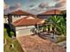 Two-story house with tile roof, paver driveway, and landscaping at 1958 Altavista Cir, Lakeland, FL 33810