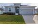Gray house with two-car garage, landscaping, and a well-maintained lawn at 252 Walkers Point Dr, Auburndale, FL 33823