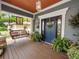 Inviting front porch with a porch swing, potted plants, and a blue front door at 304 E Palm Dr, Lakeland, FL 33803