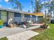 Backyard patio with awning, seating, and steps up to the back door at 3920 Timberlake E Rd, Lakeland, FL 33810