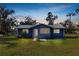 Charming blue home featuring a well-maintained lawn and a silver metal roof at dusk at 3920 Timberlake E Rd, Lakeland, FL 33810