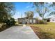 Single-story home featuring a concrete parking area and a well-maintained lawn at 3920 Timberlake E Rd, Lakeland, FL 33810