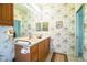Clean bathroom with seashell wallpaper, double vanity, and good storage at 4128 Aberdeen Ln, Lake Wales, FL 33859