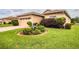 Single-story house with a tan exterior, two-car garage, and landscaped yard at 4128 Aberdeen Ln, Lake Wales, FL 33859