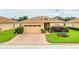Single-story house with a tan exterior, two-car garage, and landscaped yard at 4128 Aberdeen Ln, Lake Wales, FL 33859