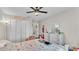 Bright bedroom featuring a ceiling fan, closet, dresser, and a cozy floral-patterned bed at 4145 Whistlewood Cir, Lakeland, FL 33811