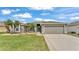 Charming home featuring a two-car garage, manicured lawn, and elegant landscaping with attractive palm trees at 4145 Whistlewood Cir, Lakeland, FL 33811