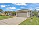 Attractive gray home featuring a two-car garage and a well-maintained lawn at 4145 Whistlewood Cir, Lakeland, FL 33811