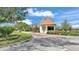 Entrance to a gated community featuring meticulously maintained landscaping and well-appointed guardhouse at 4145 Whistlewood Cir, Lakeland, FL 33811