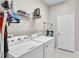 Clean laundry room featuring a washer, dryer, shelving and white door at 4145 Whistlewood Cir, Lakeland, FL 33811