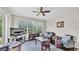 Cozy living room featuring a ceiling fan, hardwood floors, and large windows with a backyard view at 4145 Whistlewood Cir, Lakeland, FL 33811