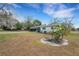 Exterior view of the white house with a front yard with light brown grass and some trees at 4380 Turner Rd, Mulberry, FL 33860