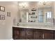 Double vanity bathroom with granite countertops and decorative shelving at 4434 Micanope Crescent Dr, Lakeland, FL 33811