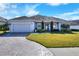 Single-story home with a grey exterior, paver driveway, and landscaped lawn at 4434 Micanope Crescent Dr, Lakeland, FL 33811