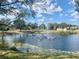 A serene pond features a fountain and is surrounded by lush greenery and neighborhood views at 4434 Micanope Crescent Dr, Lakeland, FL 33811