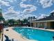 Bright community pool featuring lounge seating and covered facilities on a partly cloudy day at 4434 Micanope Crescent Dr, Lakeland, FL 33811