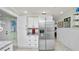 Bright kitchen featuring a stainless steel refrigerator, white cabinets, and granite countertops at 531 Hunter St, Lakeland, FL 33803