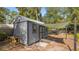 Backyard shed with weathered gray exterior and sail-shade, offers additional storage or workspace at 531 Hunter St, Lakeland, FL 33803