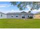 Gray house with patio, fire pit, and green lawn at 6235 Egret Dr, Lakeland, FL 33809