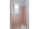 Simple bathroom with pink tile shower and a window for ventilation at 6235 Egret Dr, Lakeland, FL 33809