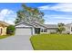 Gray house with white garage door and green lawn at 6235 Egret Dr, Lakeland, FL 33809