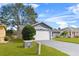 White garage door of gray house with green lawn at 6235 Egret Dr, Lakeland, FL 33809